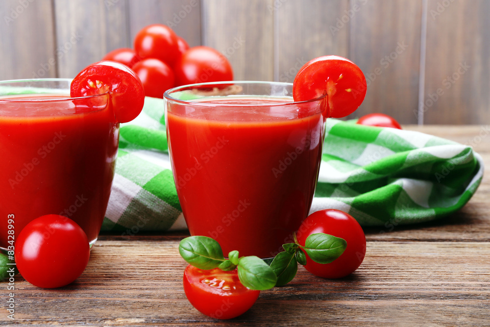 Glasses of tomato juice with vegetables on table close up Glasses of tomato juice with vegetables on table close up