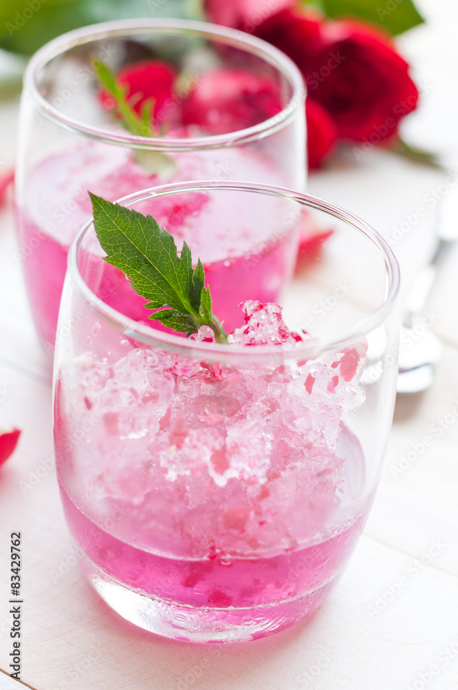 Pink Cocktail with fresh rose petals on wooden table Pink Cocktail with fresh rose petals on wooden table