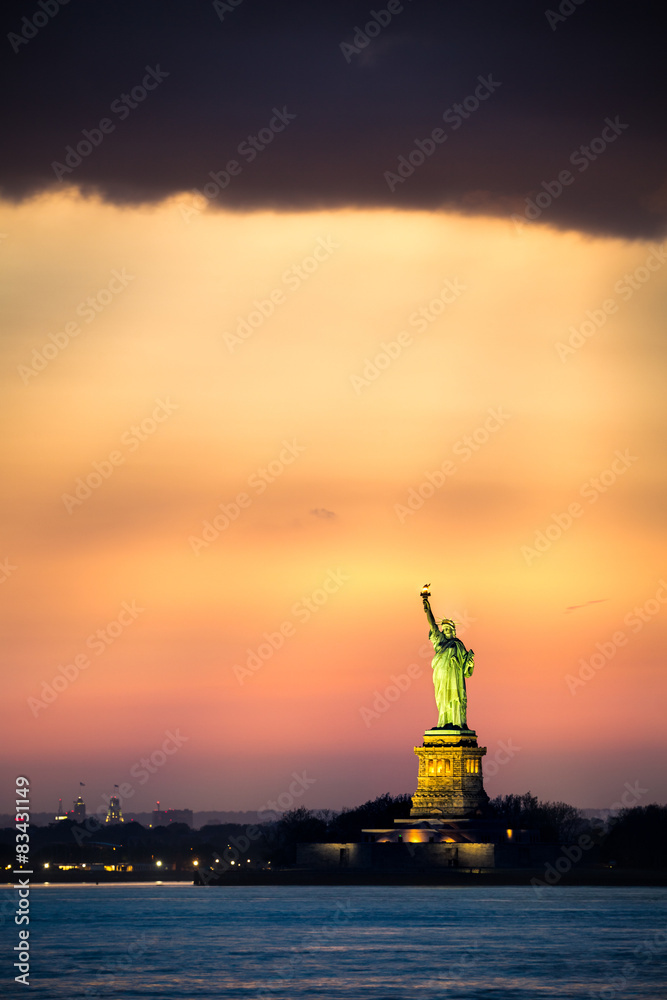 Statue of Liberty under a dramatic sunset light