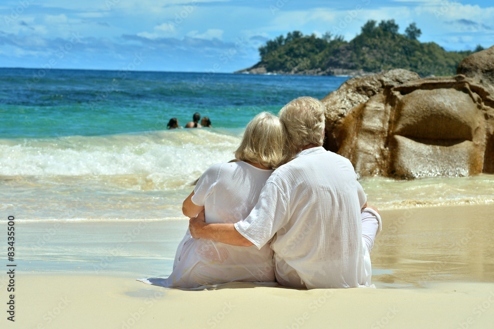 Elderly couple sitting on the shore 
