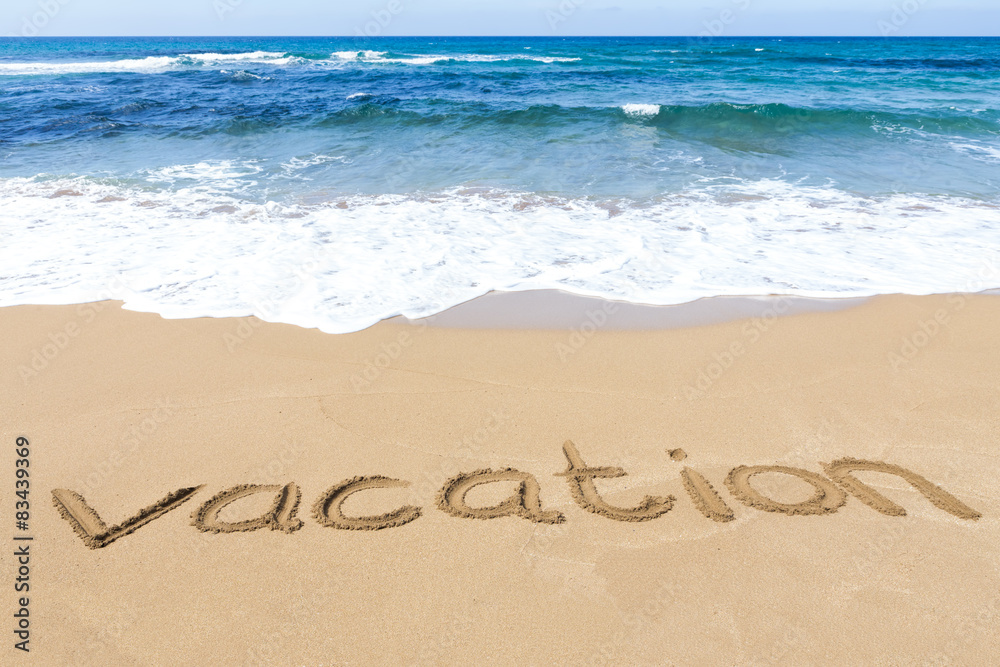 word vacation written on sandy beach at sea word vacation written on sandy beach at sea