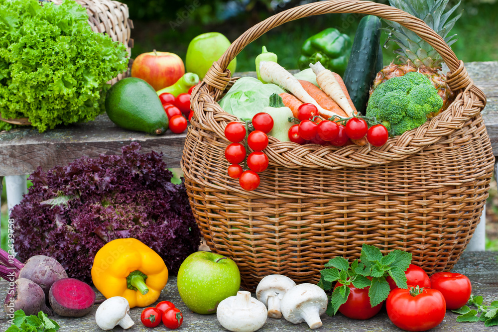 Assorted vegetables in wicker basket in the garden Assorted vegetables in wicker basket in the garden