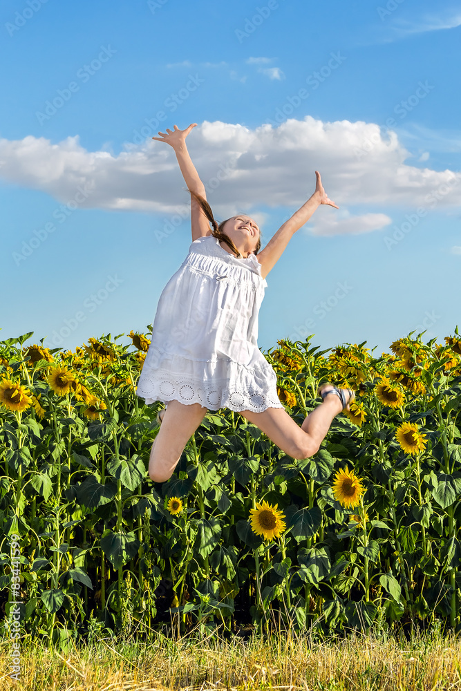 Girl jumping on a background of a field of sunflowers Girl jumping on a background of a field of sunflowers