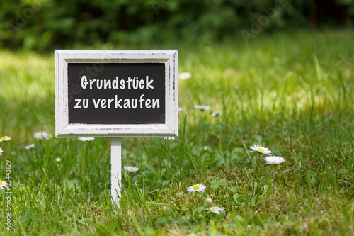 Schild im Rasen "Grundstück zu verkaufen"