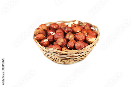 Hazelnuts in basket isolated on white