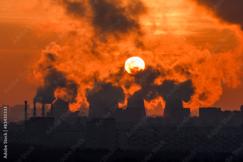 Sunset through the smoke and steam cogeneration station Sunset through the smoke and steam cogeneration station