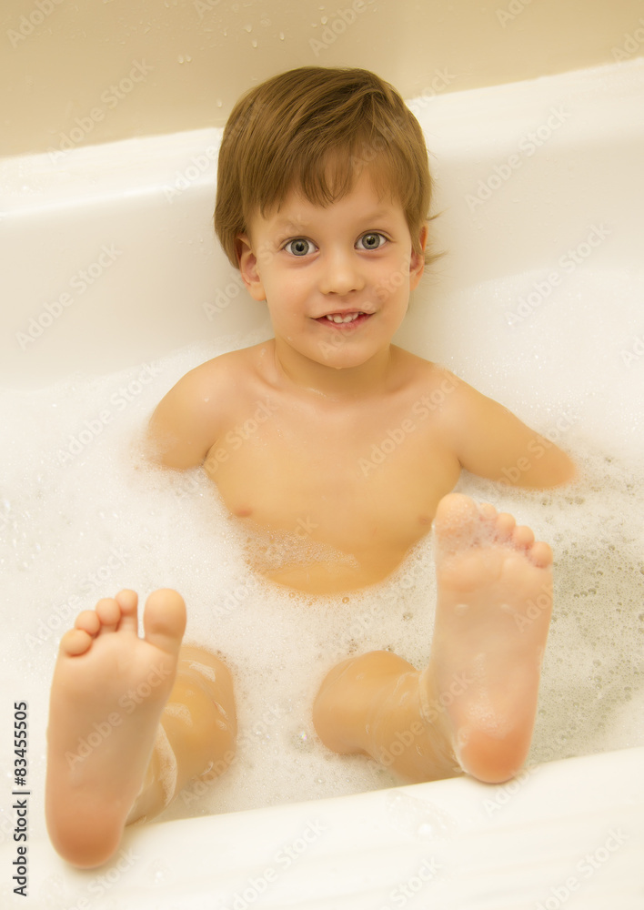 Cute three year old boy taking a bath with foam Cute three year old boy taking a bath with foam