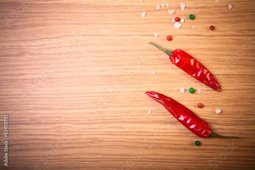 Red hot chilli pepper with sea salt and colored pepper on wooden