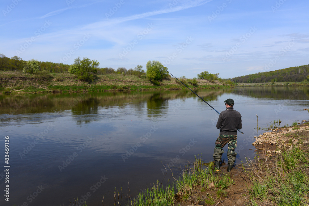 fisherman with a fishing rod on the river