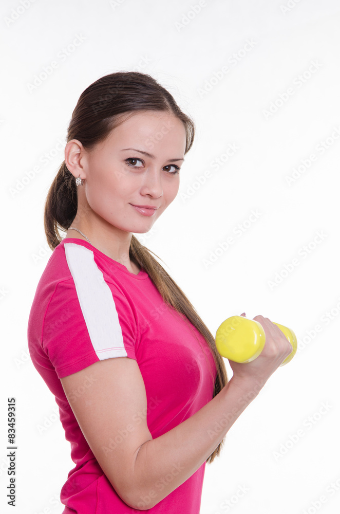 Sportswoman with dumbbells inflates his right hand Sportswoman with dumbbells inflates his right hand