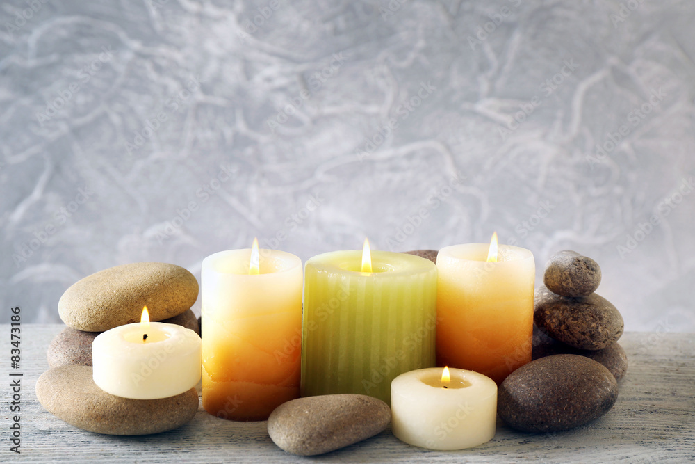 Still life with spa candles on light wallpaper background Still life with spa candles on light wallpaper background