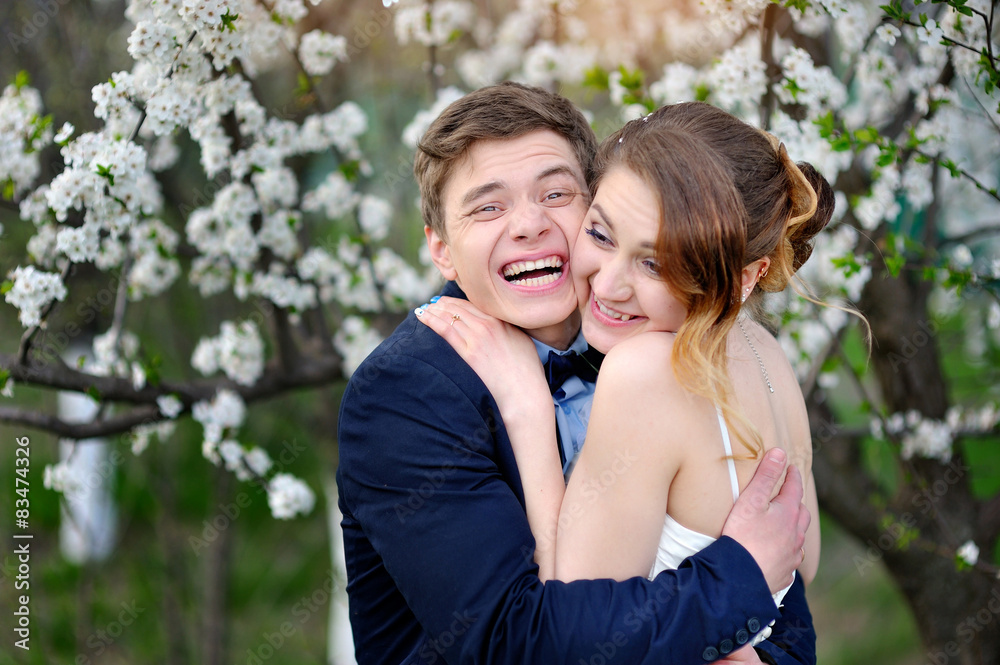 Fototapeta premium bride and groom walking in the blossoming spring garden