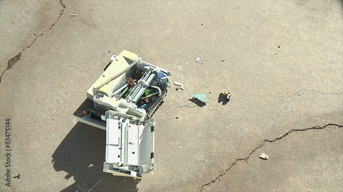 Flying Fax Falls Apart. An old fax machine crashes down onto concrete, breaking apart. Shot in slow motion at 60fps.