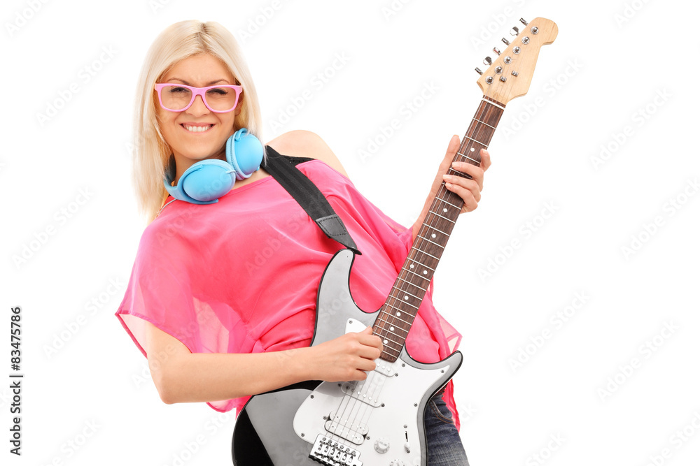 Beautiful blond woman playing a guitar and wearing blue headphon Beautiful blond woman playing a guitar and wearing blue headphon
