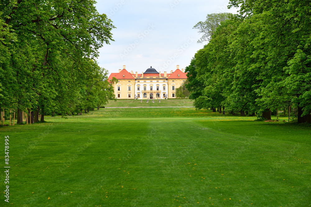Historic chateau with green trees and lawn in spring