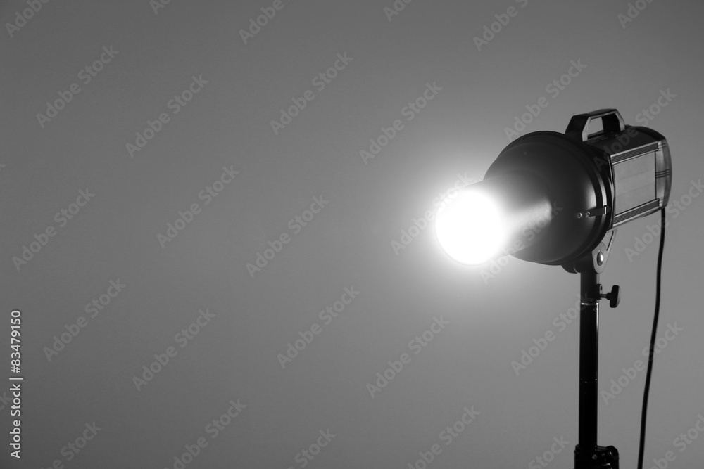 Photo studio with lighting equipment on grey wall background Photo studio with lighting equipment on grey wall background