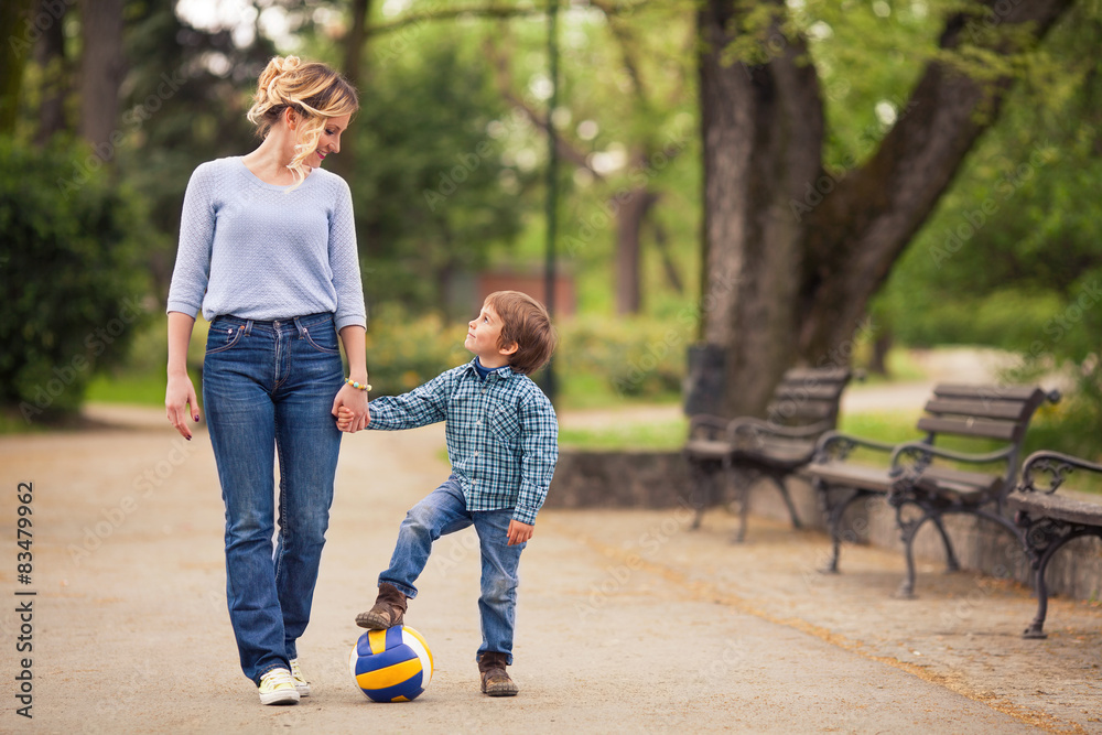 Mother and her playful little son walking in a park Mother and her playful little son walking in a park