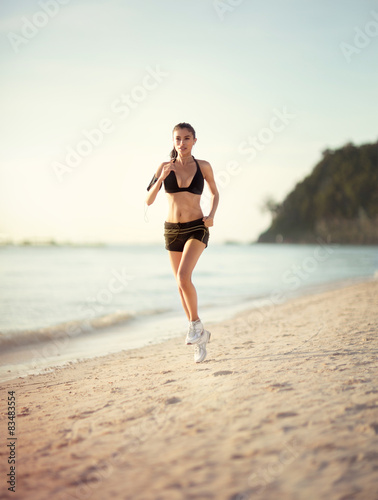 Female runner jogging during outdoor workout on beach