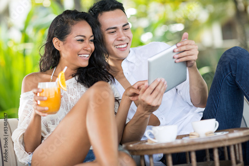 Laughing couple looking at tablet