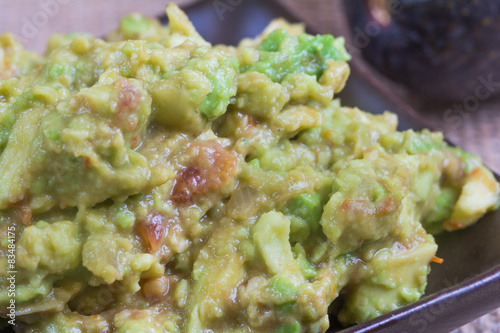 Macro close up of guacamole with tomatoes and onions