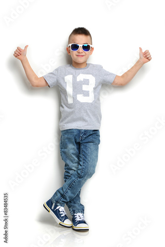 little boy in sunglasses standing and giving thumbs up sign © Dmitry Lobanov