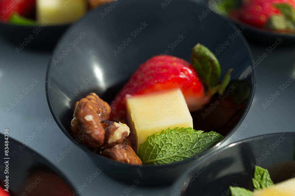 Starting party snack: cheese, strawberry, nut and mint Starting party snack: cheese, strawberry, nut and mint