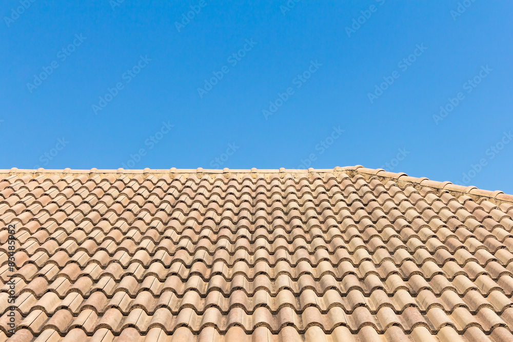 View of roof tiles and blue sky on the background View of roof tiles and blue sky on the background