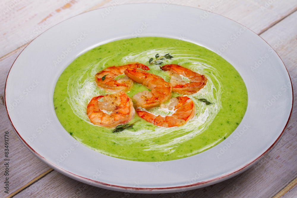 Green organic vegetable and creamy soup with shrimps