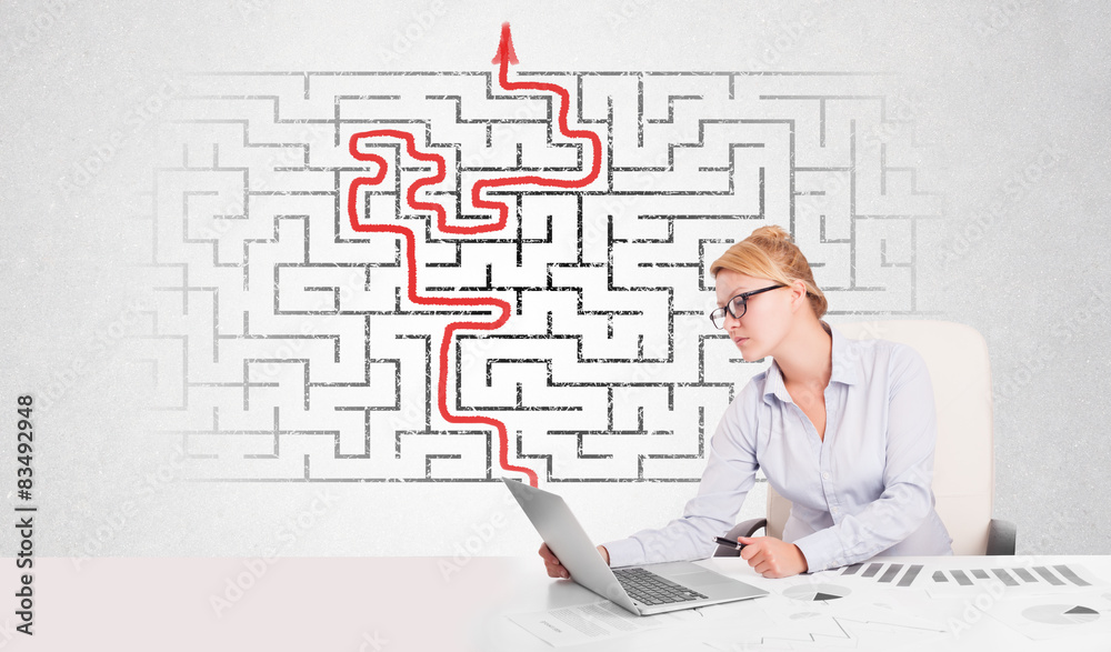 Business woman at desk with labyrinth and arrow Business woman at desk with labyrinth and arrow