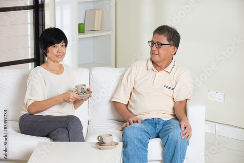 asian senior couple having drinks while relaxing