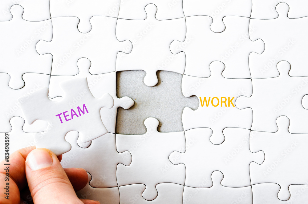 Fototapeta premium Missing jigsaw puzzle piece completing word TEAMWORK