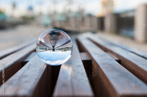 Glass transparent ball on wooden slats background. With empty