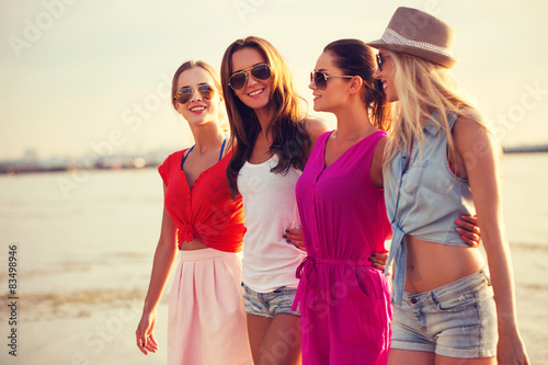 group of smiling women in sunglasses on beach © Syda Productions