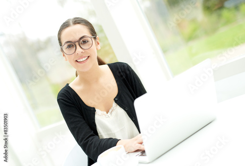 Friendly woman in eyeglasses using a laptop Free Download Friendly woman in eyeglasses using a laptop - GFXLoad
