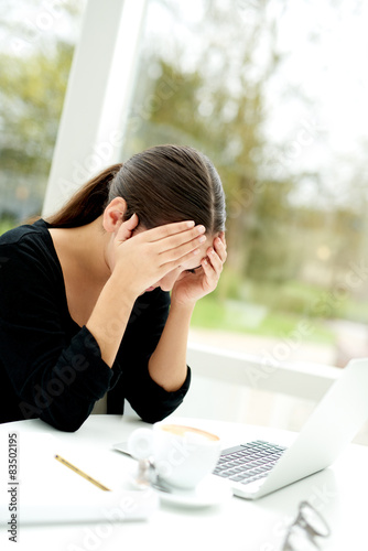 Tired worried woman resting her head in her hands