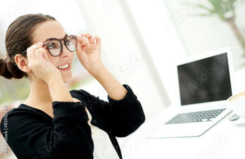 Young businesswoman adjusting her glasses photo