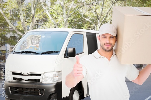 Delivery man with cardboard box gesturing thumbs up  © WavebreakMediaMicro