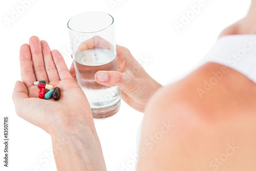Woman holding batch of pills and glass of water © WavebreakMediaMicro