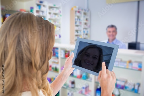 Composite image of woman using tablet pc 