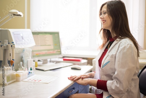 A doctor sits at a table with a computer