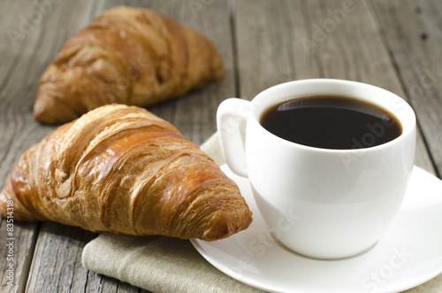coffee on a wooden table with croissants