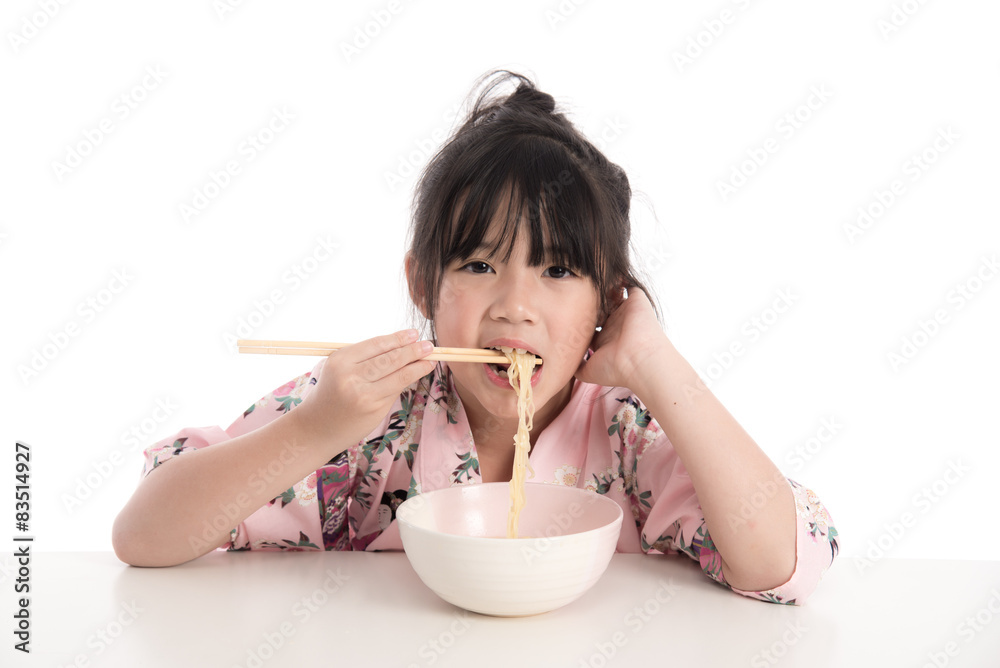 Little asian girl wearing kimono and eating noodles Little asian girl wearing kimono and eating noodles