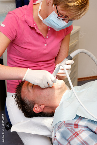 man visiting the dental hygienist for cleaning and checkup