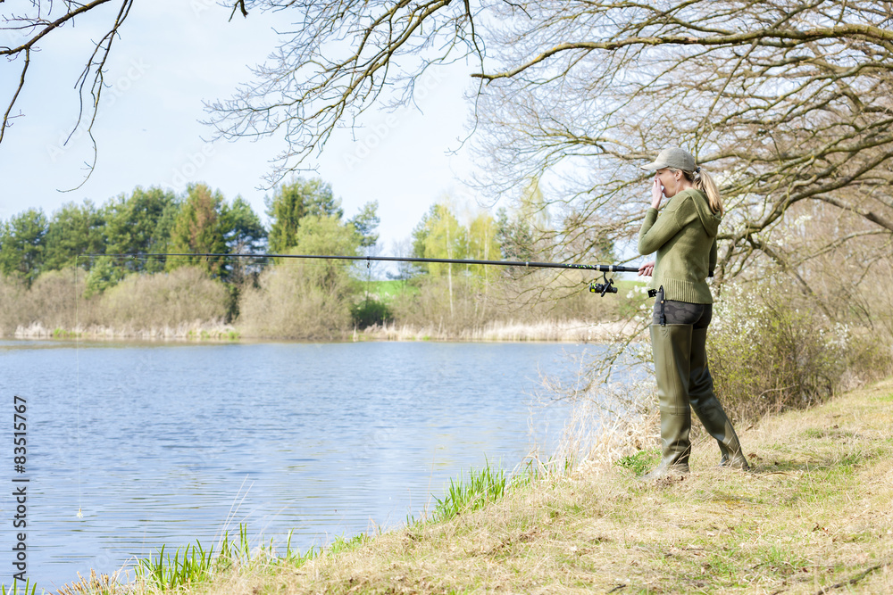 woman fishing at pond in spring