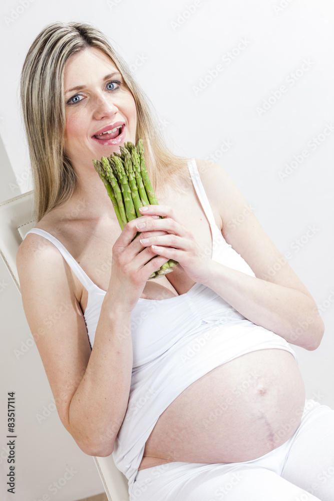portrait of pregnant woman holding green asparagus portrait of pregnant woman holding green asparagus