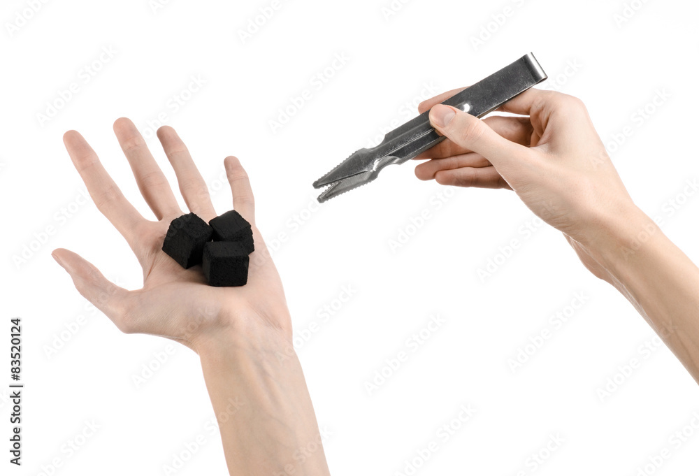 man holding a forceps with coal and puts them into a clay bowl man holding a forceps with coal and puts them into a clay bowl
