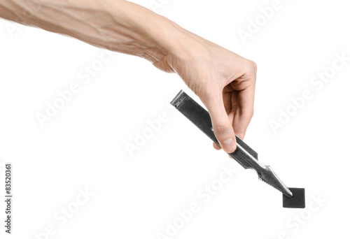 man holding a forceps with coal and puts them into a clay bowl