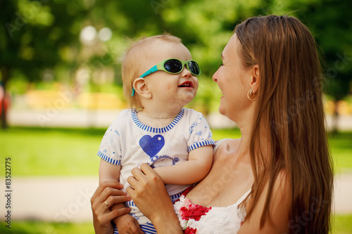 Hugging Happy Mother and Little Son on Green background in Summe