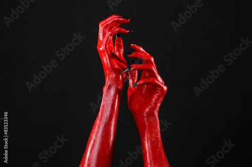Red Devil's hands, red hands of Satan, black background isolated