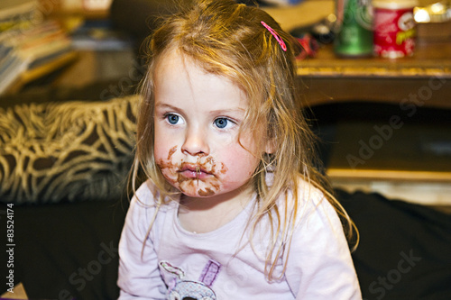 Little girl with chocolate around mouth photo